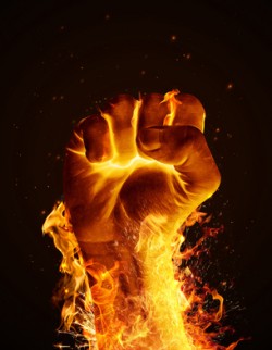 Hand consumed in flames on black background