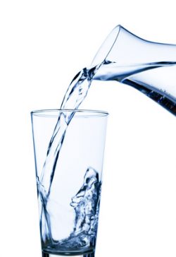 Wasser wird in ein Wasserglas eingefüllt